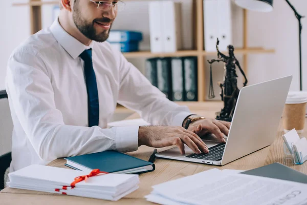 Partial view of lawyer working on laptop at workplace in office — Stock Photo