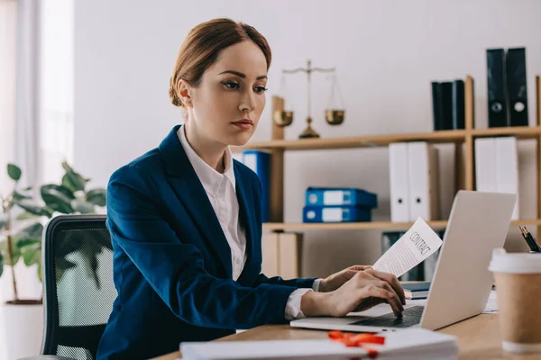 Focused female lawyer working on laptop at workplace in office — Stock Photo