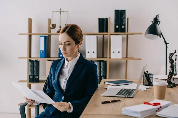 Avocate en costume avec des documents en mains au travail au bureau — Photo de stock