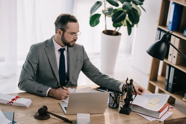 Porträt eines Rechtsanwalts im Anzug, der am Arbeitsplatz mit Laptop im Büro arbeitet — Stockfoto