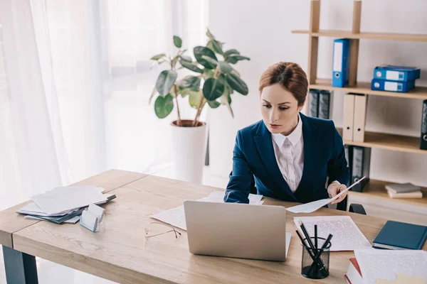 Porträt einer Geschäftsfrau im Anzug, die am Arbeitsplatz im Büro am Laptop arbeitet — Stockfoto