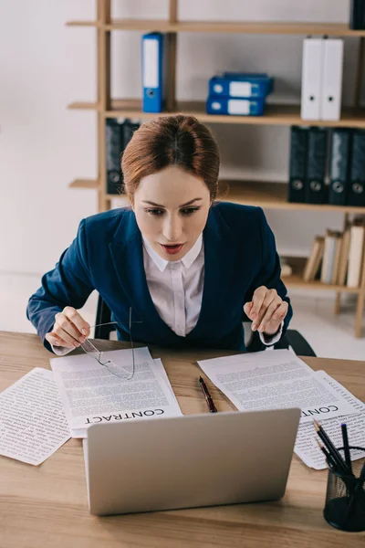Retrato de mulher de negócios em terno olhando para a tela do laptop no local de trabalho no escritório — Fotografia de Stock