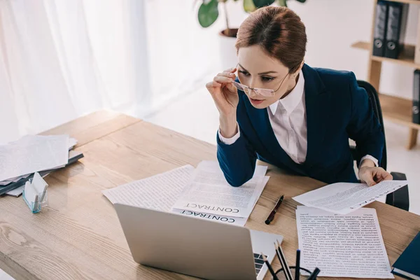 Retrato de mulher de negócios em óculos olhando para a tela do laptop no local de trabalho no escritório — Fotografia de Stock