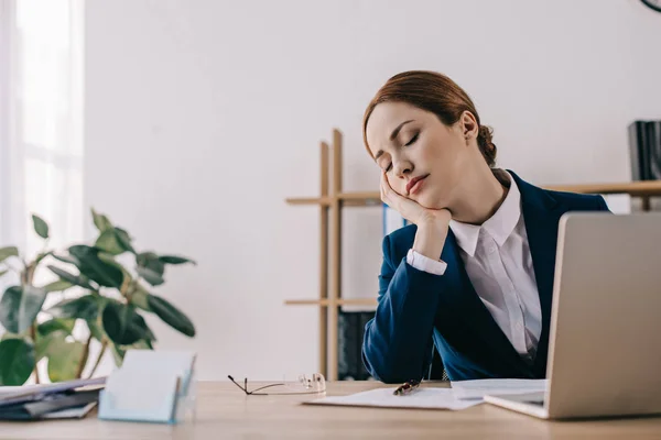 Retrato de la mujer de negocios cansada durmiendo en el lugar de trabajo en la oficina - foto de stock