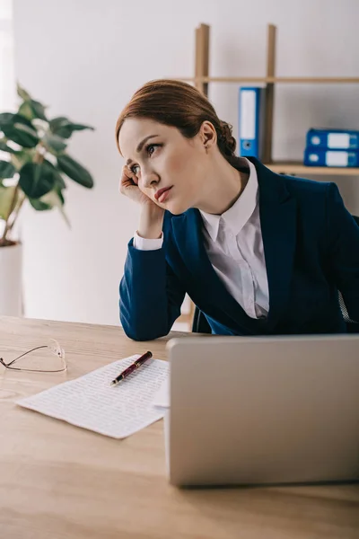 Retrato de empresária cansada olhando para o local de trabalho com laptop no escritório — Fotografia de Stock