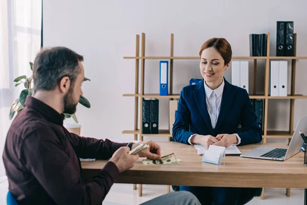 Man giving bribe to businesswoman at workplace in office — Stock Photo