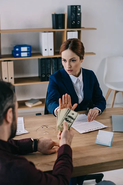 Hombre dando soborno a la mujer de negocios en el lugar de trabajo en la oficina — Stock Photo