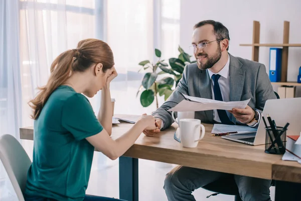 Hombre de negocios y cliente estrechando la mano durante la reunión en la oficina - foto de stock