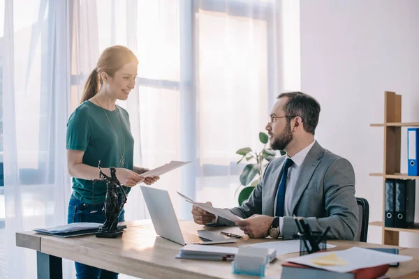 Lawyer and smiling client discussing contract at workplace with laptop in office — Stock Photo