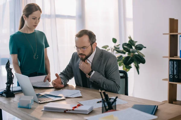 Focused lawyer and client at workplace with laptop in office — Stock Photo