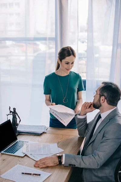 Rechtsanwalt und Mandant mit Vertrag diskutieren am Arbeitsplatz mit Laptop im Büro — Stockfoto