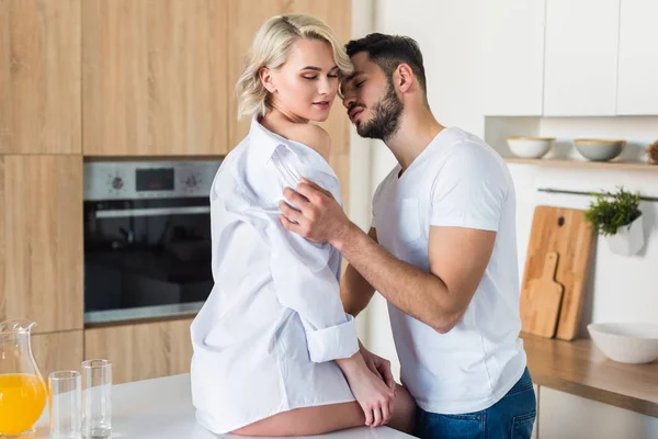 Сексуальная молодая пара обнимается на кухне по утрам — стоковое фото