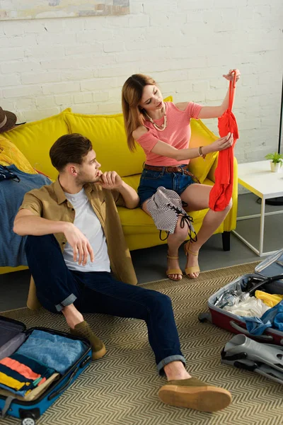 Young couple packing clothes and preparing for a vacation — Stock Photo