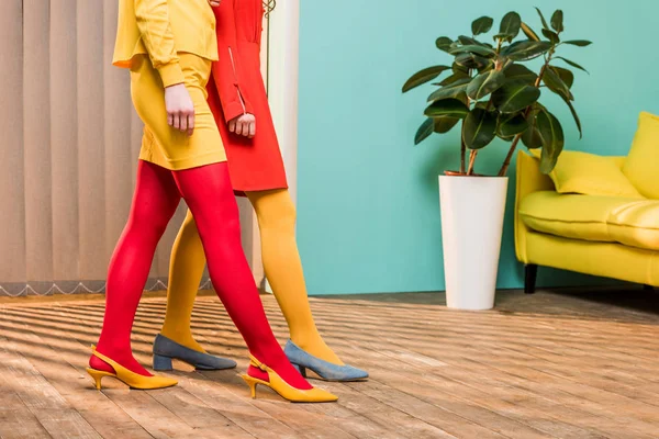 Tiro recortado de mulheres em roupas brilhantes no apartamento colorido, conceito de casa de boneca — Fotografia de Stock