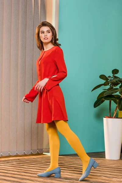 Side view of thoughtful young woman in bright clothing at colorful room, doll house concept — Stock Photo