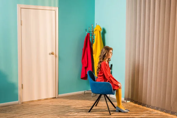 Side view of pensive retro styled woman sitting on chair at bright apartment, doll house concept — Stock Photo