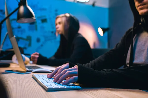 Pareja de hackers en cuarto oscuro - foto de stock