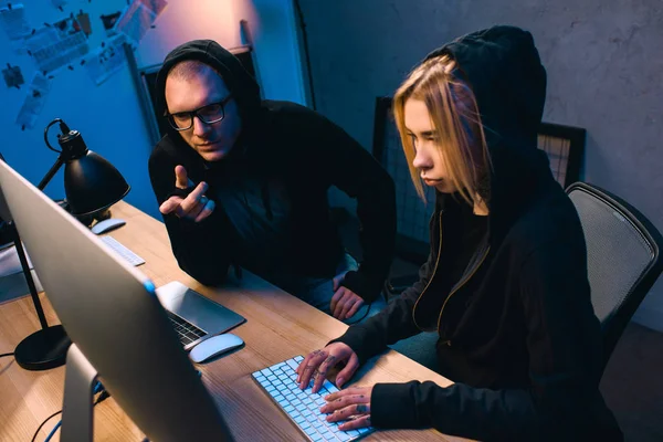 Couple confiant de pirates travaillant sur les logiciels malveillants ensemble — Photo de stock