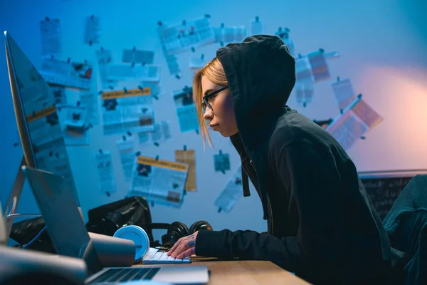 Visão lateral do hacker feminino desenvolvendo malware no quarto escuro — Fotografia de Stock