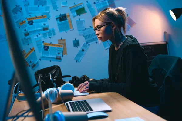 Vista laterale del giovane hacker femminile che sviluppa malware in camera oscura — Foto stock