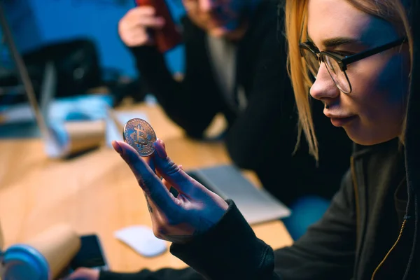 Close-up shot of female hackers holding bitcoin — Stock Photo