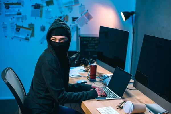 Hacker femelle dans le masque développement de logiciels malveillants sur le lieu de travail — Photo de stock