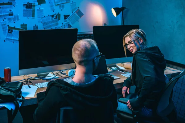 Young couple of hackers working on malware together in dark room — Stock Photo