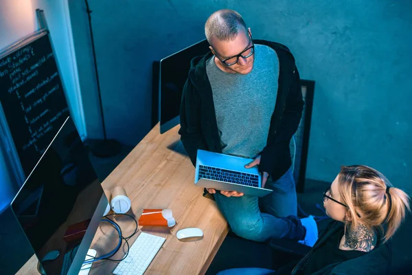 High angle view of couple of hackers working on malware together in dark room — Stock Photo