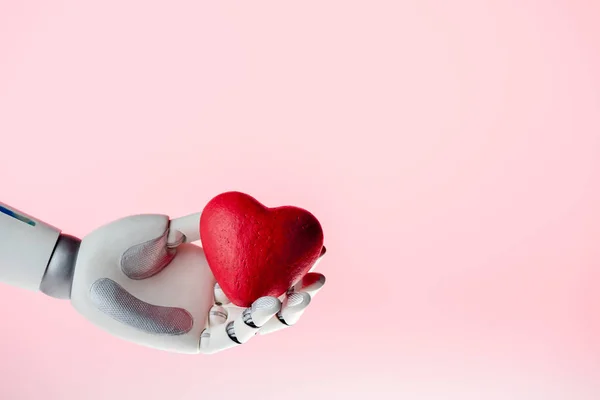 Robot hand holding red heart isolated on pink — Stock Photo