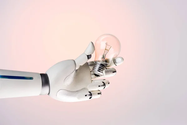 Robot hand holding lamp isolated on beige — Stock Photo