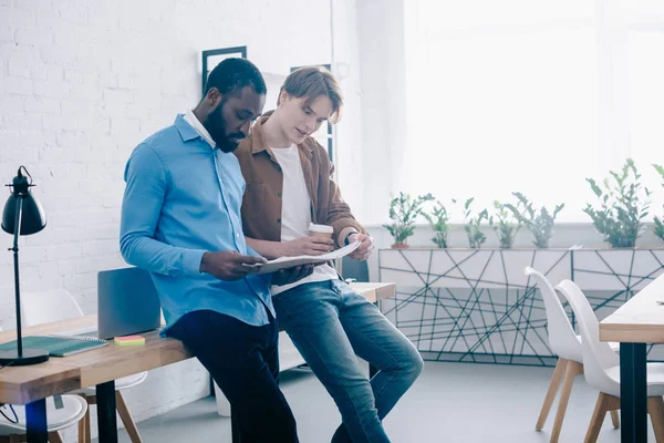 Uomini d'affari alla moda che parlano e guardano sul libro di testo in ufficio moderno — Foto stock