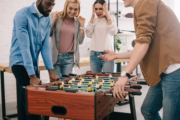 Abgeschnittenes Bild von Geschäftsleuten, die vor weiblichen Kollegen Tischfußball spielen — Stockfoto