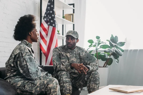 Mulher e homem de uniforme do exército conversando no sofá em casa — Fotografia de Stock