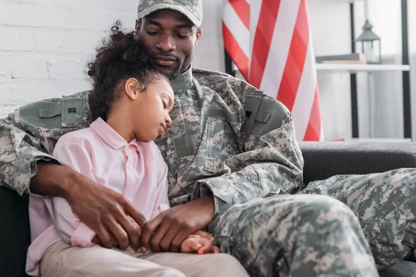 Father in army uniform and african american child embracing at home — Stock Photo