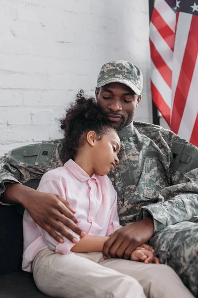 Soldado del ejército padre mirando a su adormilada hija - foto de stock