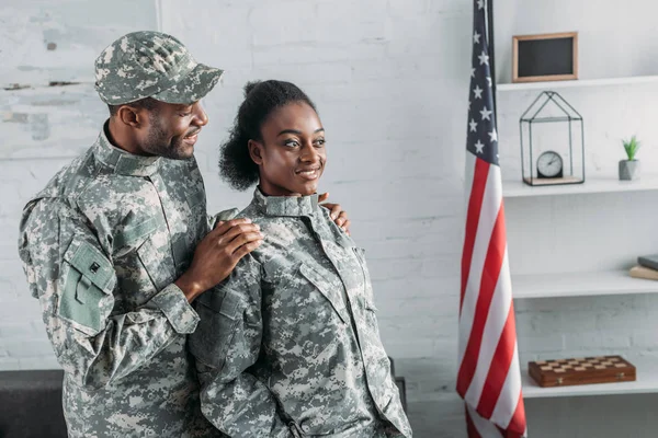 Afrikanischer amerikanischer Soldat umarmt Frau in Tarnkleidung — Stockfoto