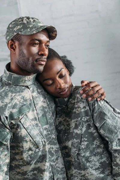 Mulher e homem de uniforme do exército abraçando em casa — Fotografia de Stock