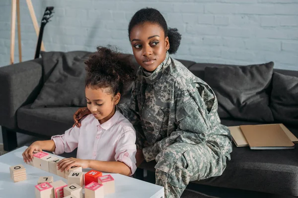 African american female soldier with daughter playing words game — Stock Photo