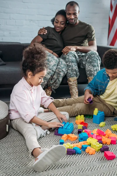 Soldados del ejército con niños felices jugando con constructor - foto de stock