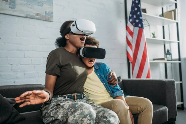 Femme soldat afro-américaine avec son fils utilisant des lunettes vr — Photo de stock