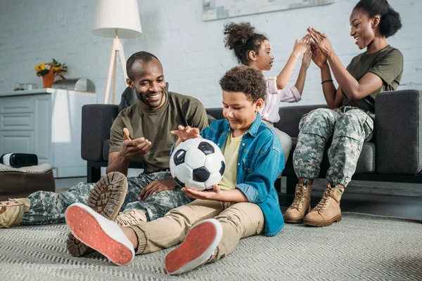 Mujer y hombre en uniforme del ejército con sus hijos disfrutando del tiempo juntos - foto de stock