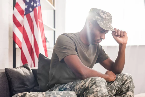 Afrikanischer amerikanischer Soldat in Tarnkleidung sitzt auf Sofa — Stockfoto