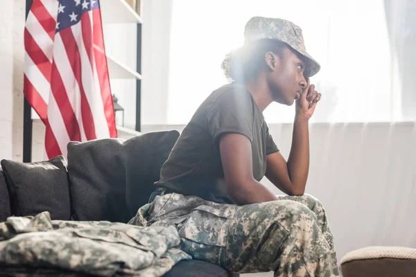 Mujer soldado afroamericana sentada en un sofá - foto de stock