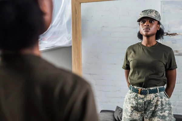 Mulher americana africana confiante em roupas de camuflagem posando pelo espelho — Fotografia de Stock