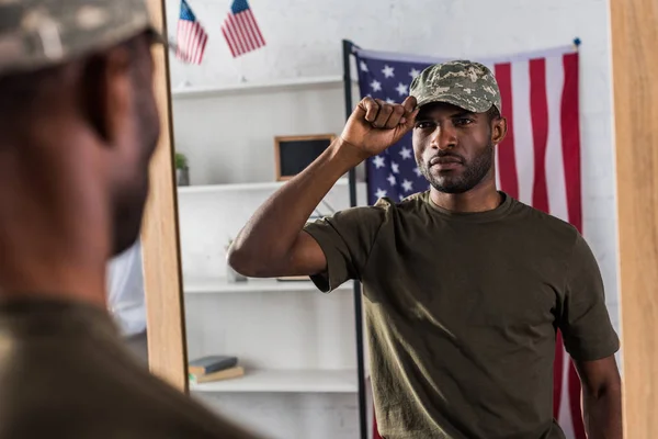 Homem americano africano confiante em roupas de camuflagem posando pelo espelho — Fotografia de Stock