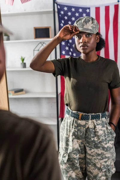 Jeune soldat en camouflage posant près du miroir — Photo de stock