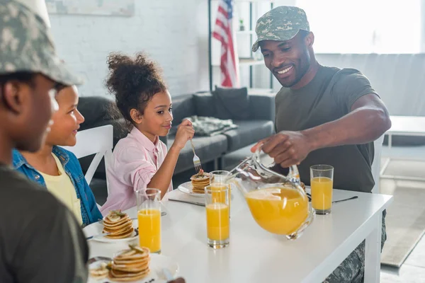 Щаслива сім'я з дітьми та батьками в армійському одязі насолоджується сніданком — Stock Photo