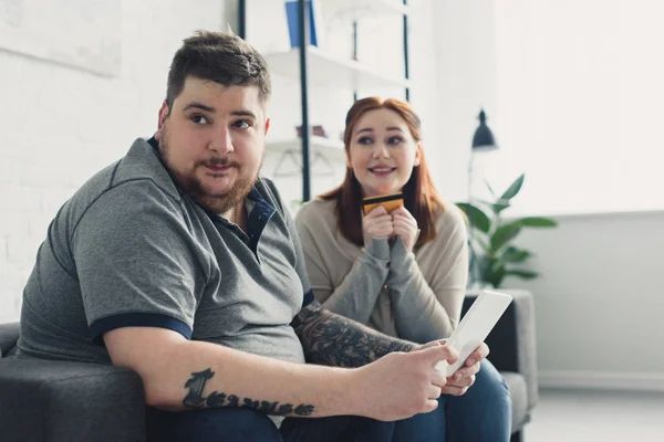 Fidanzata chiedendo fidanzato di shopping online a casa — Foto stock