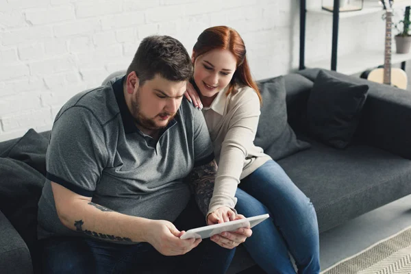 Freund und Freundin schauen zu Hause etwas am Tablet — Stockfoto