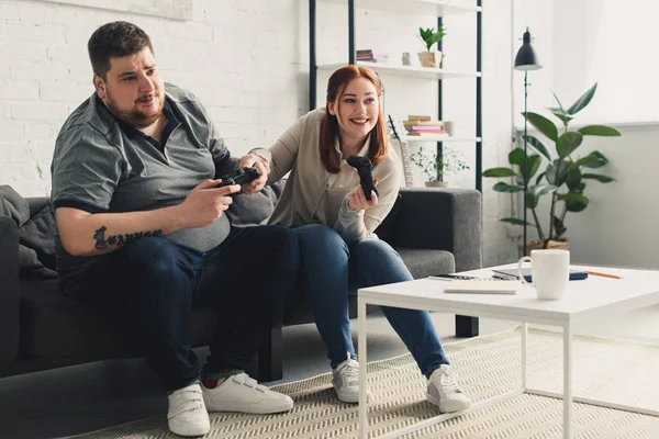 Novio y novia feliz jugando videojuego en casa - foto de stock